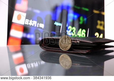 Japanese Five Hundred Yen Coins On Obverse (jpy) On Reflex Floor With Black Wallet And Digital Board