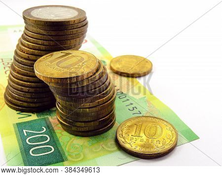 Piles Of Russian Coins Of 10 Rubles Are On A Bill Of 200 Rubles. Not Isolated. Announcements And Adv