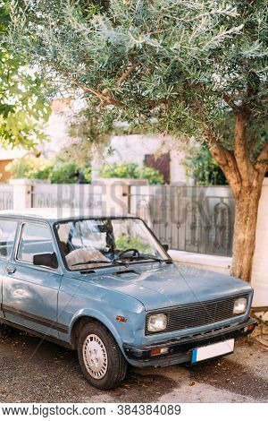 Zabljak, Montenegro - 23 July 2020: An Old Blue Car Parked Under An Olive Tree In Montenegro, Perast
