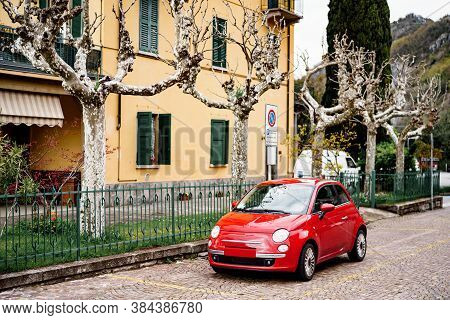 Milan, Italy - 29 July 2020: A Red Fiat 500 Car Parked Outside A House With Sycamore Trees, Or China
