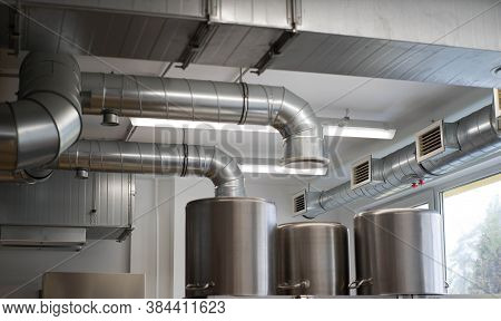 Metal Pipes. Ventilation System In Modern Restaurant Kitchen. Stainless Steel Pans.