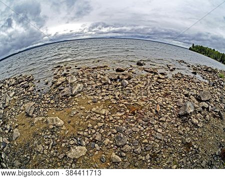Rocky Shore Of Lake Uvildy In Inclement Weather, Sky With Gray Clouds, Fishay Lens
