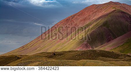 Close-up Of The Slope Of The Mountain With Red Sand. Grazing Horses. Kyrgyz Nature.