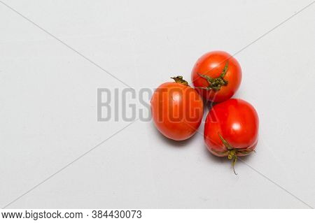 juicy red tomatoes in table cloth . caro background