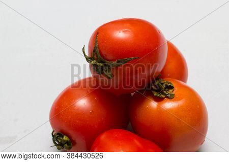 juicy red tomatoes in table cloth . caro background