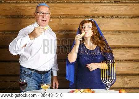 A Jewish Family, A Husband In A Kippah And A Wife In A Cape On Their Heads In Rosh Ashana Eat Challa