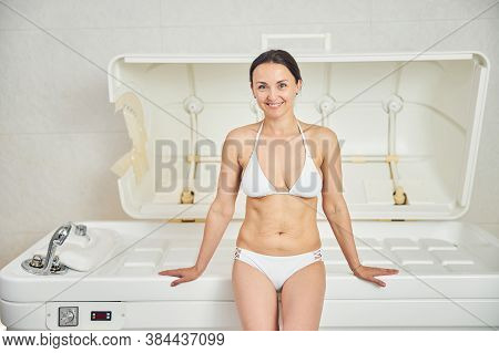Happy Lady Enjoying Treatment In Beauty Salon With Modern Equipment
