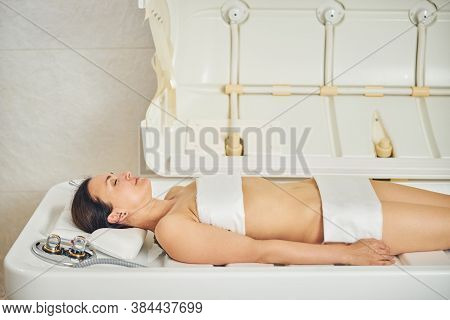 Calm Woman Ready For The Body Wrap Treatment In Beauty Salon