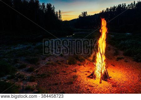 Landscape Of Forest And River. Sunset Sky. Huge Fire. Midsummer Ligo Celebration. Latvian Tradition.