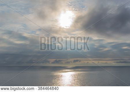 Cloudy Sunset With The Sun Trying To Get Out Among The Clouds And Reflecting On The Sea