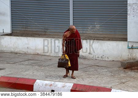 Yangon, Myanmar Feb 24, 2019: Myanmarese Buddhist Monk Standing Beside The Road In Yangon.