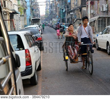 Yangon, Myanmar Feb 24, 2019: Myanmarese Passenger Sitting On The Bicycle Tricycle Taxi With The Dri