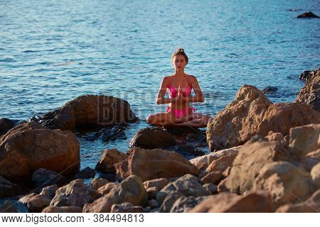 Alone Time. Meditation And Self-absorbed. Calm Lady In Pink Bikini Meditating On Rock. Calm Sea. Spa