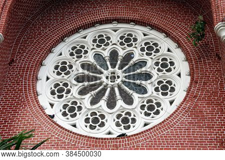 White Circle Mortar Flower Pattern With Stained Glass And Red Brick Of Exterior Of Church Gable At C