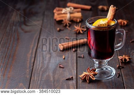 Red Glogg Or Mulled Wine With Orange Slices And Cinnamon Stick On A Dark Wooden Background, Horizont