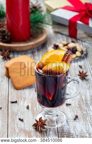 Red Glogg Or Mulled Wine With Orange Slices And Cinnamon Stick, Gingerbread Cookies And Gift Box On 