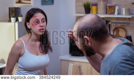 Traumatised Woman Yelling At Drunk Man Holding A Bottle Of Wine. Abused Terrified Beaten Wife Covere