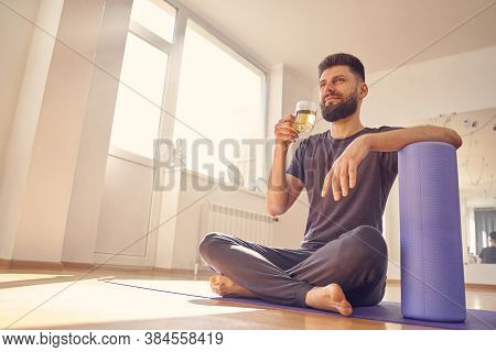 Bearded Young Man Drinking Herbal Tea In Yoga Studio