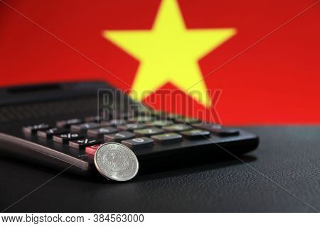Two Hundred Vietnam Dong Coin On Obverse (vnd) With Black Calculator On Black Floor And Vietnam Flag