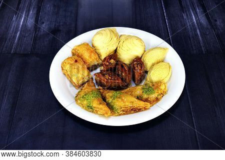 Oriental, Turkish, Azerbaijani Baklava Sweets In A White Plate On A Brown Wooden Table.