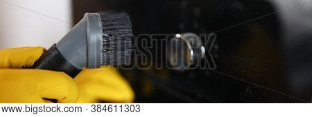 Close-up Of Persons Hand Cleaning Cookstove Display With Nozzle Of Vacuum Cleaner. Male In Protectiv