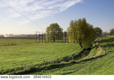 Green Meadow With Trees Along A Dike Close To The Bakkerskil Fortress Near The Dutch Village Werkend