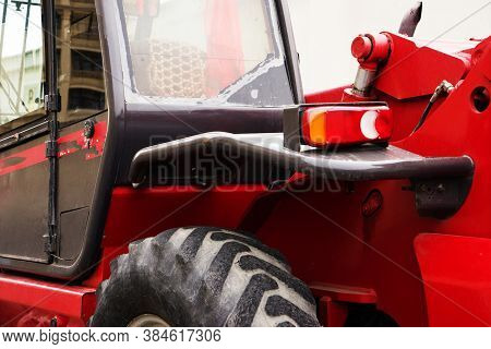 A Red Forklift Truck Stands On A Rough Terrain In The Yard.