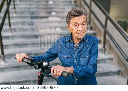 Old Woman Near Scooter. Grandmother Progressive Woman. Senior Having Fun. Old Woman Enjoying Her Hob