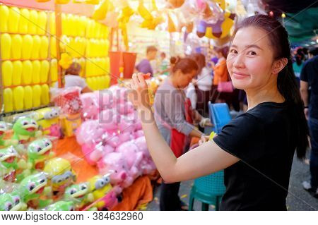 Khonkane, Thailand - March 21, 2017: Young Woman Playing A Bubble Shooter Kids Toys And Gifts Vendor