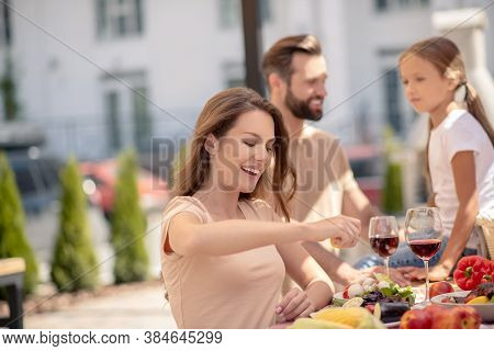 Pretty Woman Sqeezing Lemon While Having Dinner With Family