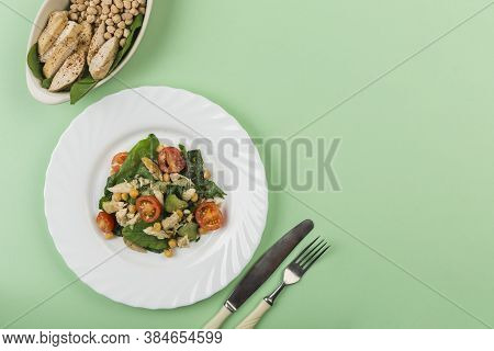 Summer Salad Of Fresh Spinach, Cherry Tomatoes, Cucumbers And Chicken Fillet On A White Plate With A