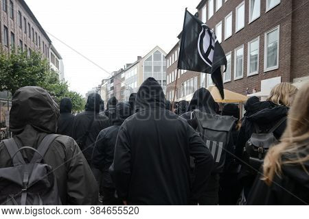 Black Dressed Protesters On A Demonstration March Through The Streets Of Lubeck Against German Polit
