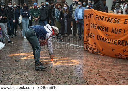 Lubeck, Germany, September 09, 2020: Demonstrator Sprays A Slogan On The Street On The Demonstration