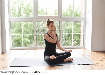 Stong Sporty Woman Practicing Yoga, Doing Alternate Nostril Breathing Exercise, Nadi Shodhana Pranay