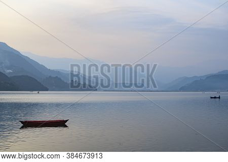 View Over A Colorful Boat On Phewa Lake In Pokhara, Nepal With The Surrounding Mountains. Clear Sunn