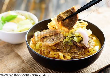 Northern Thai Food (khao Soi), Spicy Curry Noodles Soup With Beef In A Bowl Eating By Chopsticks