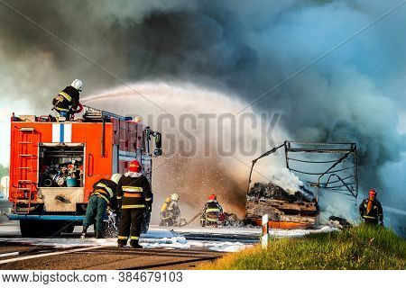 Firefighters Put Out The Fire With Foam In The Car, Fire Engine Extinguishes A Fire On The Road