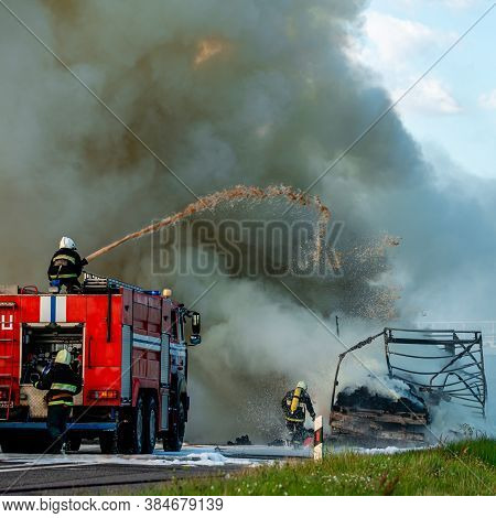 Firefighters Put Out The Fire With Foam In The Car, Fire Engine Extinguishes A Fire On The Road