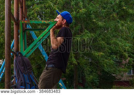Athlete Doing Pull-up On Horizontal Bar. Male Sportsman Doing Fitness Exercises On Playground Outdoo