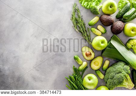 Green Vegetables Background. Сucumber, Avocado, Broccoli, Beans, Leek And Fresh Apple On Grey Stone 