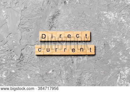 Direct Current Word Written On Wood Block. Direct Current Text On Cement Table For Your Desing, Conc
