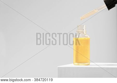 The Product Is A Moisturizing Serum For The Care Of Female Skin On A White Stand. Orange Essential O