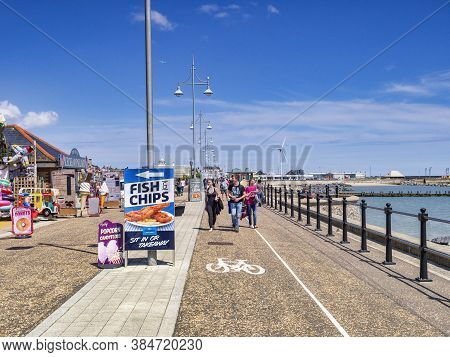15 June 2019: Lowestoft, Suffolk, Uk - Young Couple Strolling On The Promenade On A Sunny Summer Day