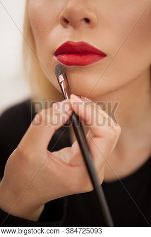 Vertical Cropped Shot Of A Makeup Artist Using Concealer Around The Lips Of A Woman With Red Lipstic