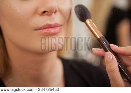Cropped Shot Of A Woman Smiling While Makeup Artist Applying Highlighter On Her Face