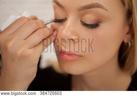 Young Beautiful Woman Getting False Lashes Applied By Professional Makeup Artist