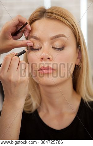 Vertical Portrait Of A Beautiful Woman Getting Professional Makeup At Beauty Studio