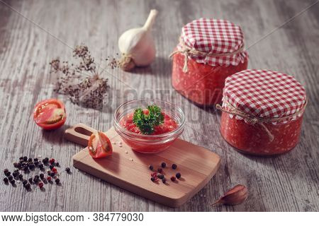 Homemade Spicy Appetizer Of Horseradish, Tomato And Garlic In Jars On A Wooden Table