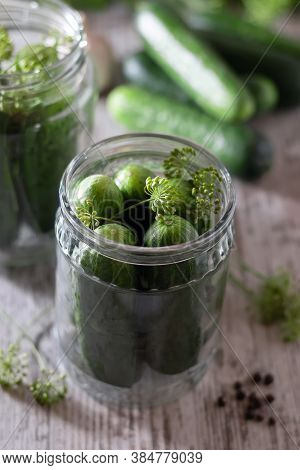 Pickled, Pickled Cucumbers In A Jar On A Wooden Table. Cucumbers, Herbs, Dill, Garlic. Preservation,