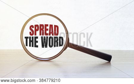 Magnifying Glass With Text Spread The Word On Wooden Table.
